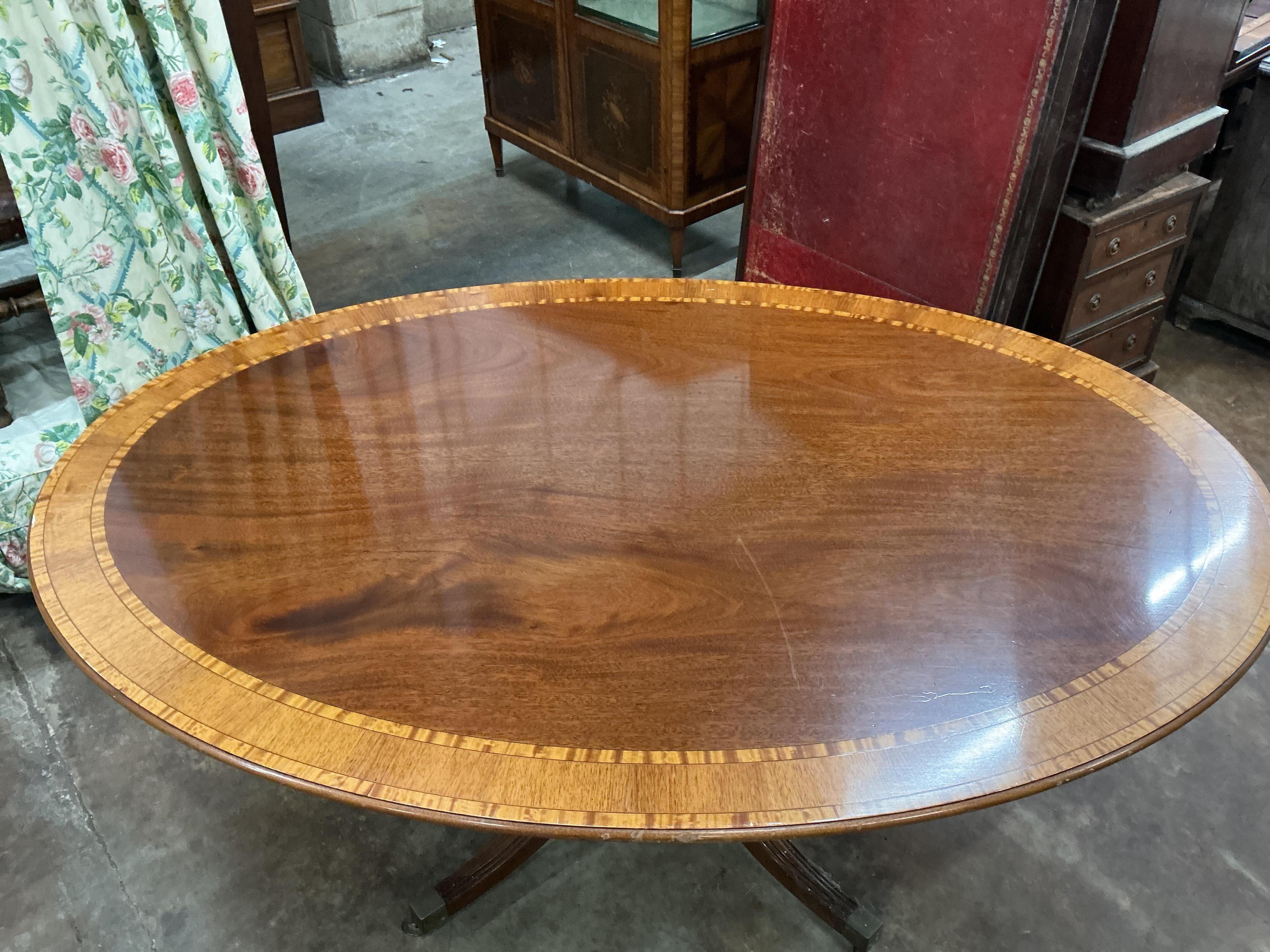 A reproduction William Tillman George III style oval banded mahogany dining table (lacks bolts), width 168cm, depth 120cm, height 72cm